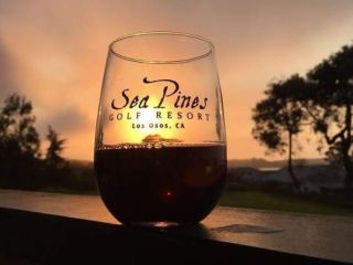 Red wine in Sea Pines Golf Resort branded wine glass on balcony at sunset