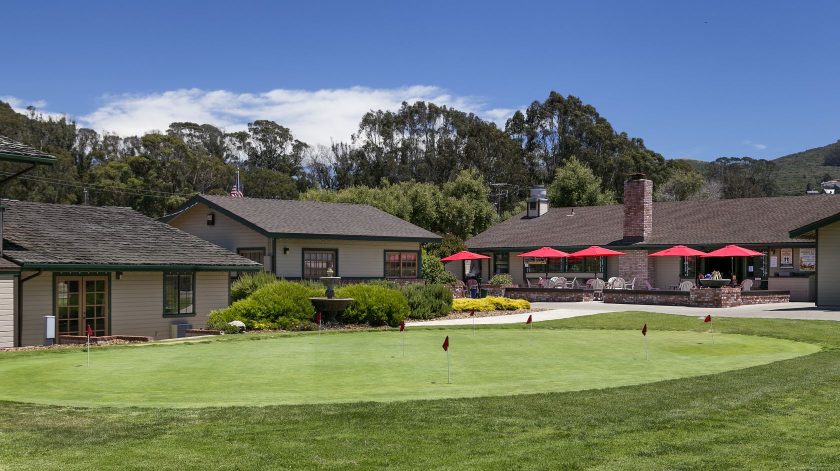 Putting green and patio dining outside The Clubhouse Bar and Grill at Sea Pines Golf Resort in Los Osos
