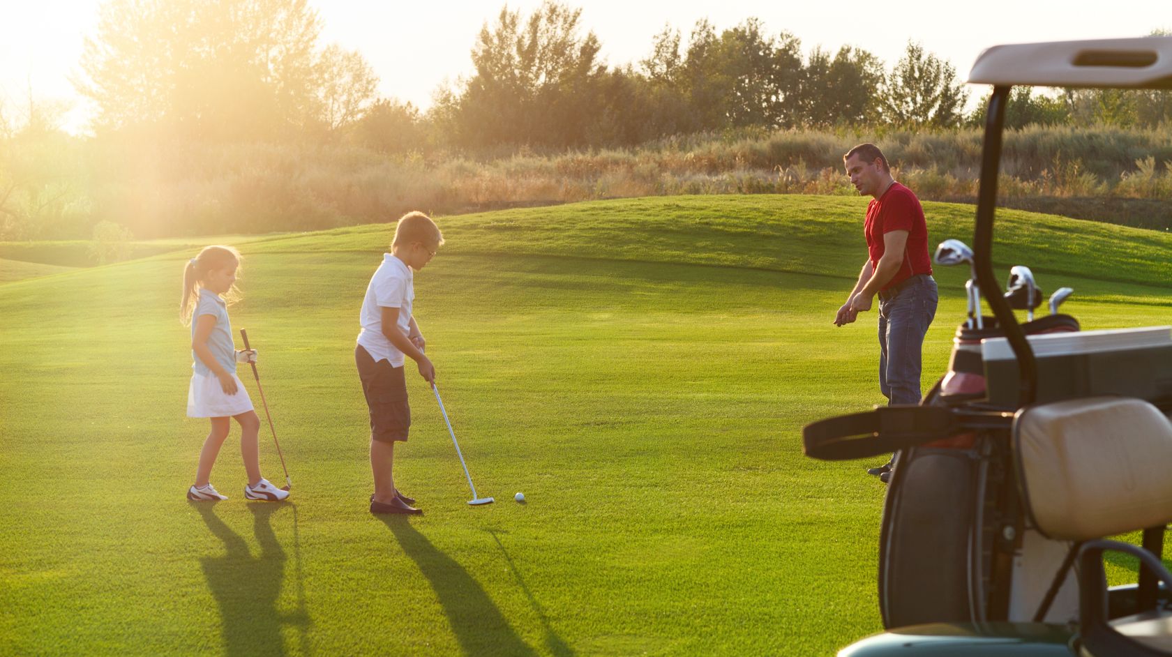 Man gives two children golf lessons at Sea Pines Golf Resort Junior Golf program