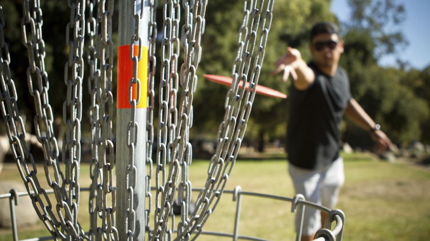 Man throws Frisbee into net during a game of Disc Golf at Sea Pines Golf Resort in Morro Bay
