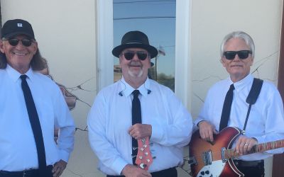 A Group Of Men In Ties And Hats Holding Guitars